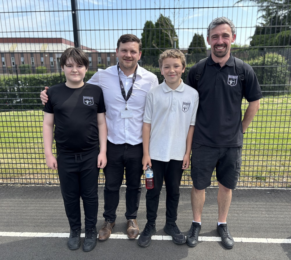 Headteacher Toby Ellis stand with two pupils and Outdoor Education Lead Tom Kirby